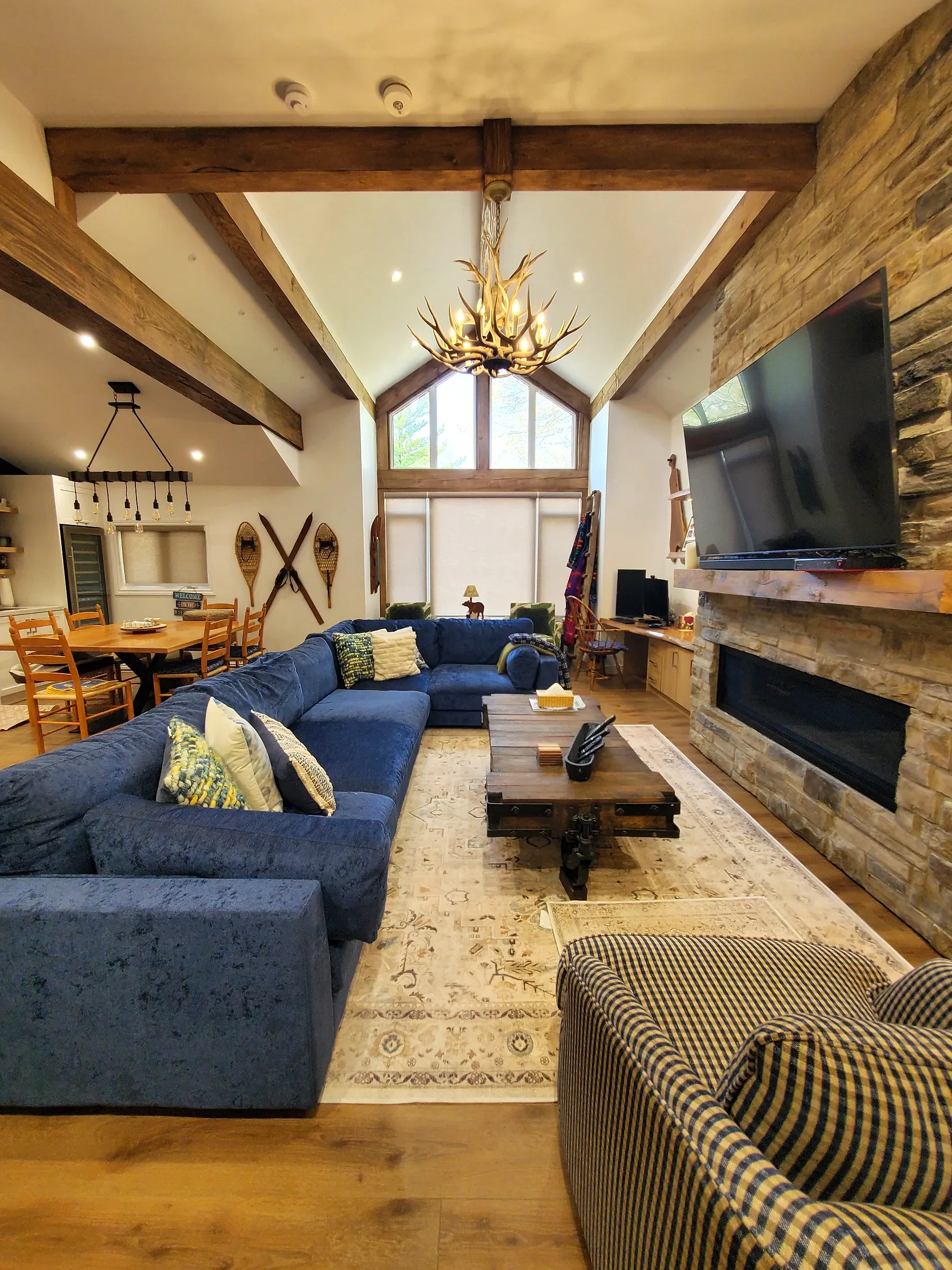 Finished Ferreira living area with stone fireplace and exposed wood beams